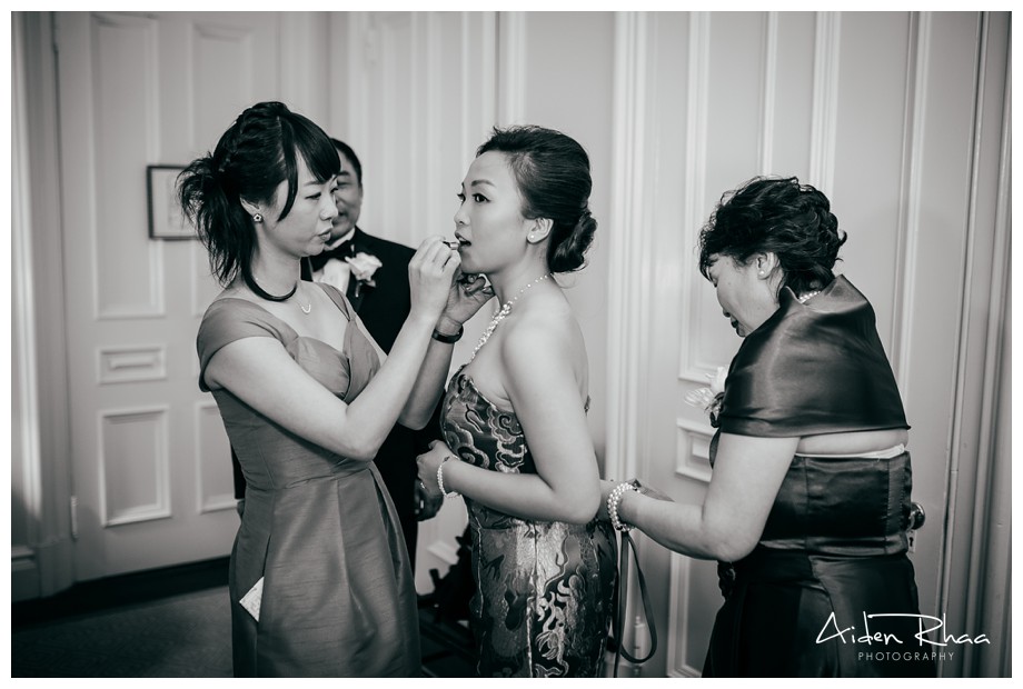 mom and maid of honor helping bride